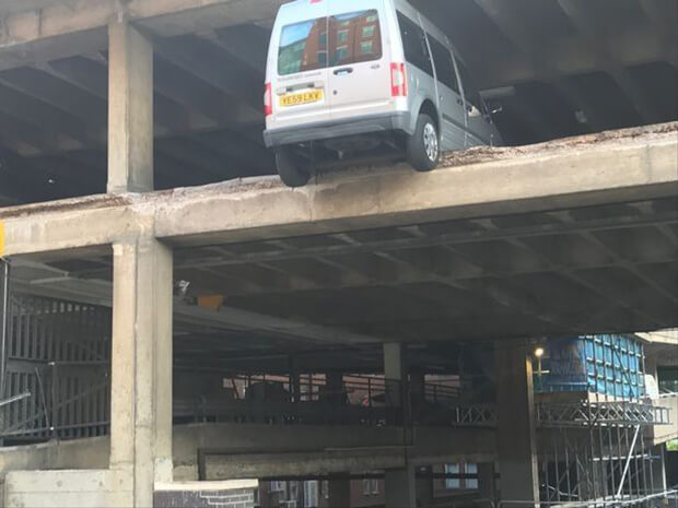 A City centre multi-story car park partially collapses and leaves vehicles dangling from upper floors 50ft above ground