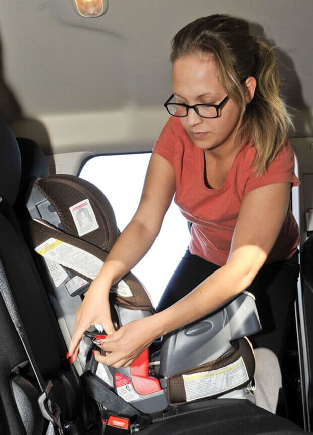 Mother Adjusting Child Car Seat